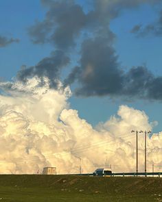 a large field with power lines and clouds in the background