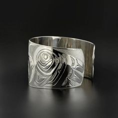 "This rare Northwest Coast Native cuff fuses Celtic/British design with First Nations symbolism. This piece is comprised of two 'Ravens' in reverse, and their interlocking tongues create Celtic knotting. This composition represents both family, and British Columbia's colonial heritage. An elegant and significant work of art. This cuff measures 1 1/2\" wide and 6 1/4\" long, which will fit a wrist between 6 1/2\" - 7\" in circumference. Custom lengths and widths can be requested as well. It is si Celtic Raven, Northwest Coast, British Design, Hand Engraving, North West, Cuff Bracelet, Native American, Nativity, Cuff Bracelets