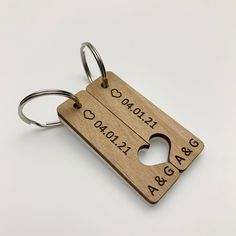 a wooden keychain with two hearts engraved on the front and back, hanging from a metal ring