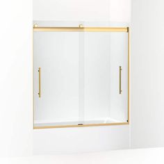 a bathroom with a white wall and a gold framed shower door on the side of it