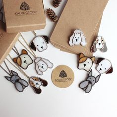 the dog and bear necklaces are on display in front of some brown paper bags