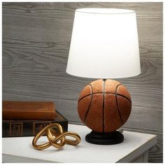 a lamp with a basketball on it next to a book and a pair of scissors