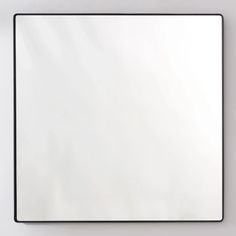 a square mirror mounted to the side of a wall