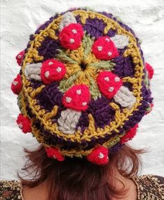 a close up of a person wearing a crocheted hat with flowers on it