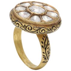 A beautiful ring with Flat Rose cut diamonds and intricate enamel work on the side and the back. These Flat Diamonds are called "Polki". The diamonds are set in the piece using "Kundan" which is pure gold. This technique of using pure gold to set the stones can be seen in old Mughal Jewelry as well. The Black enamel work done on the side and the back has a floral motif with leaves and flowers flowing throughout. The beautiful ring definitely makes a statement. Ring Size: US 7 Mughal Jewelry, 22k Gold Ring, Rose Cut Ring, Gold Heart Ring, Yellow Gold Diamond Ring, Celebrity Engagement Rings, Work Art, Art Deco Diamond, Enamel Jewelry