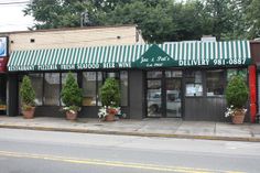 a restaurant with green and white awnings on the front