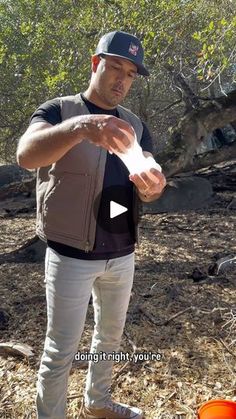 a man is holding something in his hand and pointing it at the camera with an orange bowl next to him