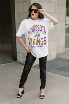 a woman wearing a minnesota shirt and black leather pants