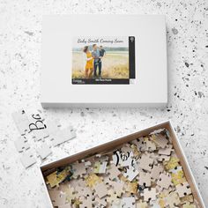 a box filled with lots of puzzles next to a couple's wedding photo