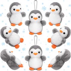 several stuffed penguins hanging from strings on a white surface with snowflakes in the background