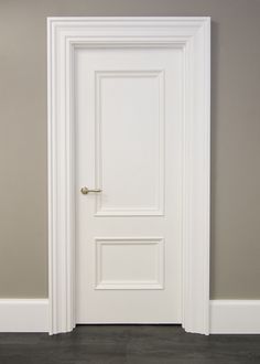 an empty room with a white door and gray walls