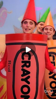 a group of people in costumes standing next to each other wearing crayon hats