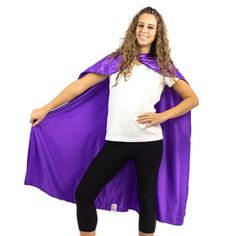 a woman wearing a purple cape and black leggings poses for the camera with her hands on her hips