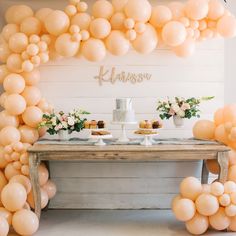 a table with desserts and balloons on it