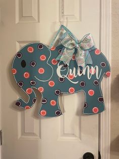 an elephant door hanger is decorated with polka dots and a bow on it's head