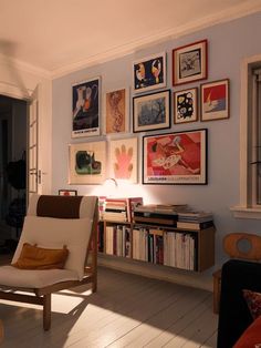 a living room filled with furniture and lots of pictures on the wall above it's bookshelf