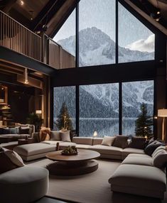 a living room filled with lots of furniture and large windows covered in snow capped mountains