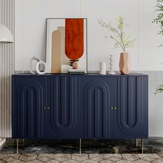 a blue cabinet with two vases sitting on top of it next to a plant