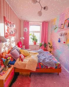 a bedroom decorated in pink and purple with lots of decorations on the walls, flooring and bedding