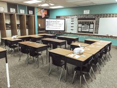 an empty classroom with desks and chairs in front of a chalkboard on the wall