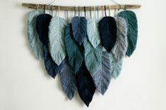 several different colored feathers hanging on a wall