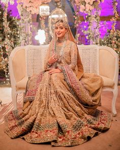 a woman sitting on top of a white couch in a wedding dress wearing a bridal outfit