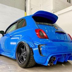 the rear end of a blue car parked in a garage