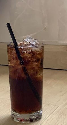 a glass filled with ice and a black straw