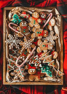 a wooden box filled with lots of different types of christmas cookies and candy canes