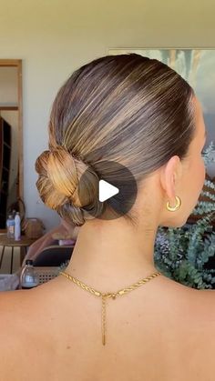 the back of a woman's head, with her hair in a low bun