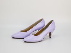 Step into elegance with these Vintage Leather Pumps in a charming lilac purple by Okidoki. Featuring a classic pointy toe and high kitten heel, these slip-on shoes combine timeless sophistication with a playful touch of color. Crafted from premium leather, they offer both comfort and durability, making them perfect for both special occasions and everyday chic. The soft lilac hue adds a unique twist to any outfit, ensuring you stand out with effortless style. Ideal as a thoughtful gift for a fash Purple Round Toe Heels For Office, Elegant Lavender Heels With Round Toe, Elegant Lavender Heels For Formal Occasions, Purple Low Heel Shoes For Spring, Purple Pointed Toe Heels For Formal Occasions, Lavender Round Toe Heels For Evening, Lavender Pointed Toe Heels For Formal Occasions, Elegant Lavender High Heels, Lavender High Heel Heels For Formal Occasions