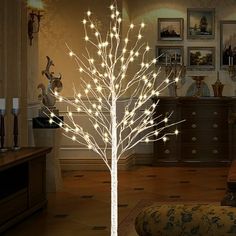 a lighted tree in the middle of a living room