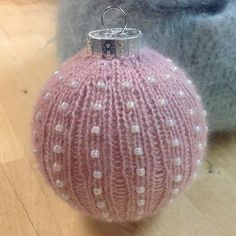 a pink ball ornament sitting on top of a wooden floor