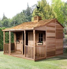 a wooden shed sitting on top of a lush green field