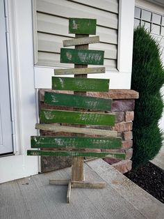 a christmas tree made out of wooden planks sitting in front of a door way