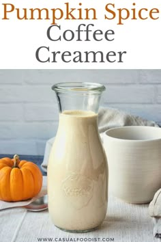 pumpkin spice coffee creamer in a glass bottle with a white bowl and spoon next to it