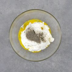 a glass bowl filled with food on top of a gray table next to a knife and fork