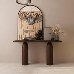 a table with a lamp and some plants on it in front of a mirror that is hanging from the wall