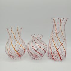 three glass vases sitting next to each other