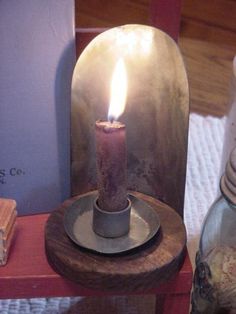 a lit candle sitting on top of a table next to some books and other items