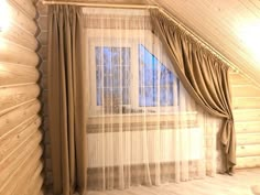 the curtains are pulled back in front of the window with sheer drapes on it