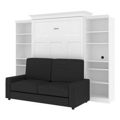 a black couch sitting in front of a white bookcase