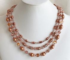 "Several different styles of copper plated beads and bead caps and Czech and Chinese glass are featured in this necklace.  Copper bronze pearls, copper lined glass faceted rounds, half coat copper crystal glass, metallic apricot faceted glass, topaz faceted cubes, and copper ended cathedral beads, different arrangements in the 3 strands, connect to copper end bars.  Copper curb chain makes up the rest of the length; it fastens with a hook and may be worn from about 18\" to 22\" (46-56cm). The co Gold Jewelry With Faceted Beads And Copper, Gold Copper Jewelry With Faceted Beads, Elegant Copper Necklaces With Round Beads, Elegant Copper Necklace With Round Beads, Triple Ring, Copper Crystal, Make Your Own Jewelry, Multi Strand Necklace, Copper Plated