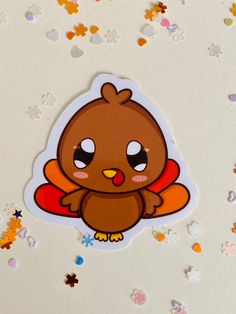 a sticker with an image of a brown bird on it's face, surrounded by confetti