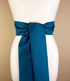 Wide Textured Deep Sea Blue Sash Belt  Dark Blue Dupioni Sash  Blue Dress Sash  Dupioni Fabric Belt  Blue Wedding & Bridesmaid  Satin Swank  Add vibrant color and crisp texture to your special occasion outfit with this Satin Swank® dupioni waist sash. Depending on your waist size and the length you choose (75 and 90 inch lengths available), you can wrap this sash around your waist once or twice. You decide whether to tie the sash in a bow or a simple knot with long-hanging tails. Tie in front, in back, or on the side. A double layer of crisp dupioni fabric in deep sea blue. Sash is the same front and back with seams hidden within the fold lines. Dupioni features a rustic weave with naturally occurring slubs running throughout the fabric resulting in exquisite depth, texture, and sheen. SIZ Blue Wedding Dress With Sashes, Elegant Blue Bridal Belt For Wedding, Blue Wedding Dress With Satin Bow, Elegant Blue Party Sashes, Elegant Blue Sashes For Wedding, Elegant Blue Dress With Sashes, Blue Tie-back Wedding Dress, Blue Tie-back Dress For Wedding, Blue Tie Back Dress For Wedding