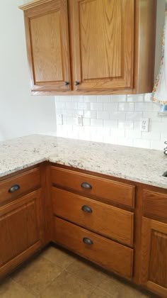 a kitchen with wooden cabinets and marble counter tops