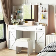 a white vanity with lights on it next to a bed and window in a room