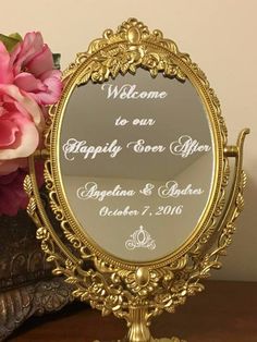 a mirror sitting on top of a table next to a vase with flowers in it