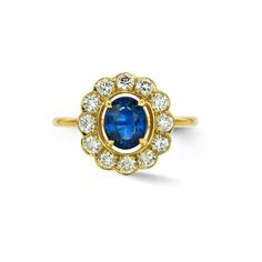 an oval blue sapphire and diamond cluster ring in 18ct yellow gold, set with diamonds