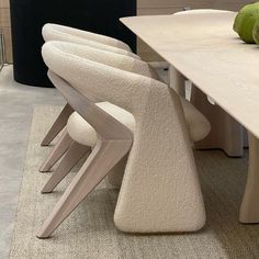 a dining room table with chairs and an apple on the counter top in front of it